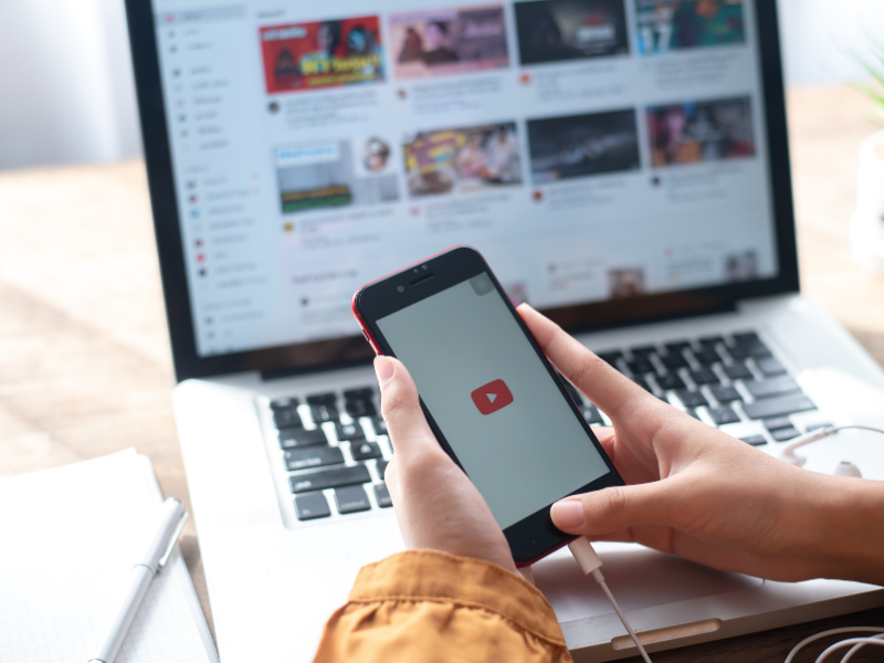 what does royalty free mean - person downloading youtube videos on PC and smartphone